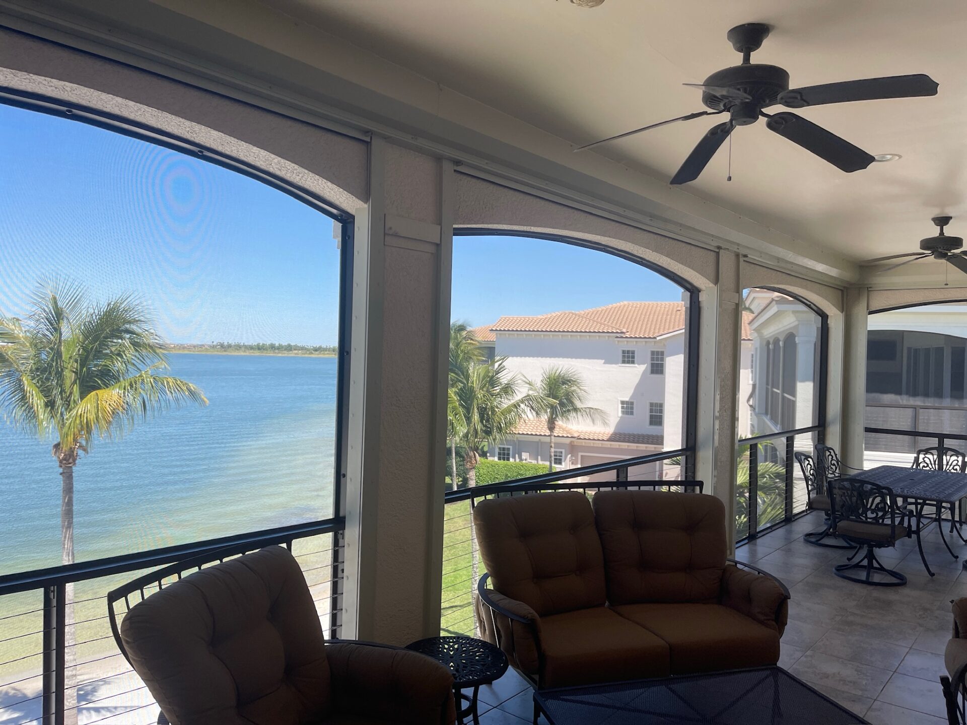 Relaxing patio setting with a picturesque view of the water and palm trees